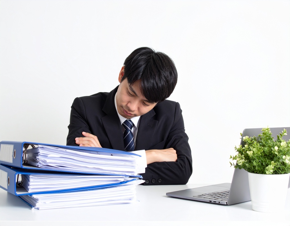 総務DXが進まなくて考え込んでいるイメージ